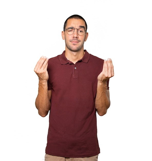 Confused young man making an italian gesture of not understand