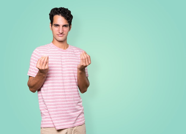 Confused young man making an italian gesture of not understand