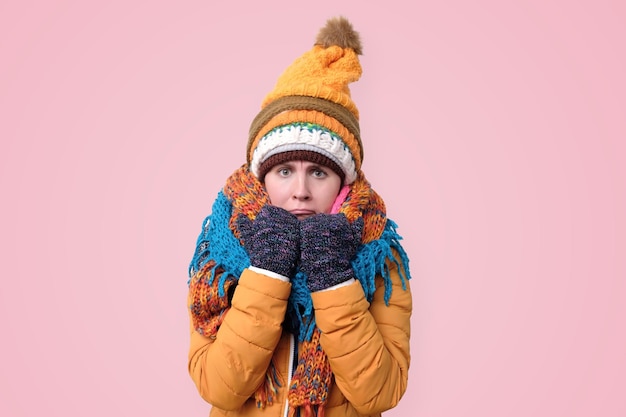 Photo confused young woman in winter scarf and hat