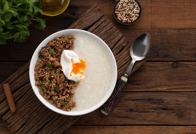 Congee rijst met varkensvlees en ei op houten tafel