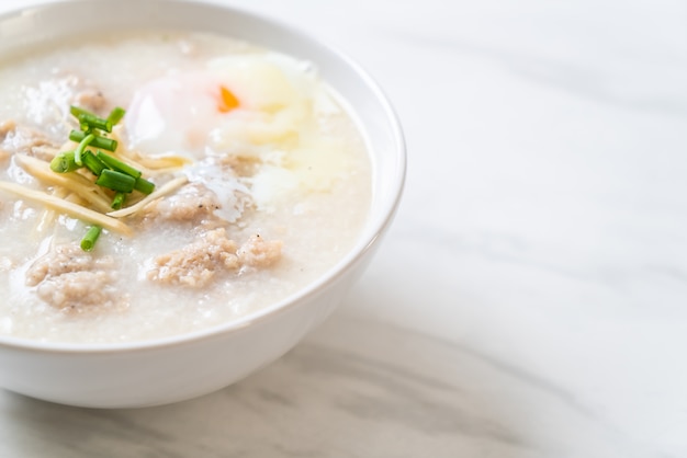 Congee con carne di maiale tritata in ciotola