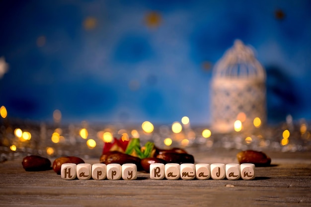 Congratulation HAPPY RAMADAN composed of wooden dices Candle holder in the background