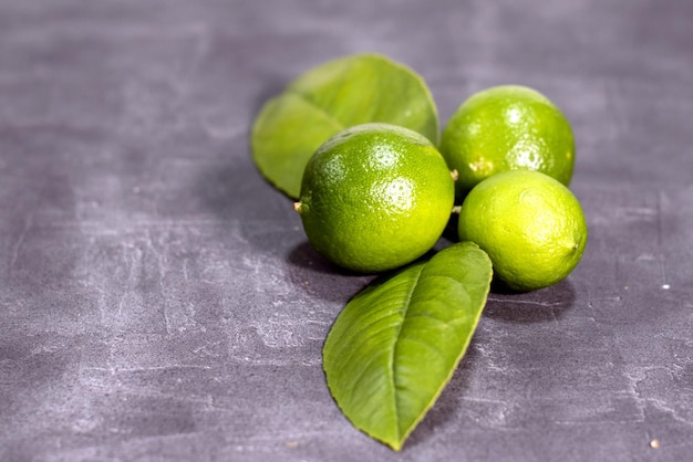 Conjunto de limones verdes fresco's sobre fondo gris