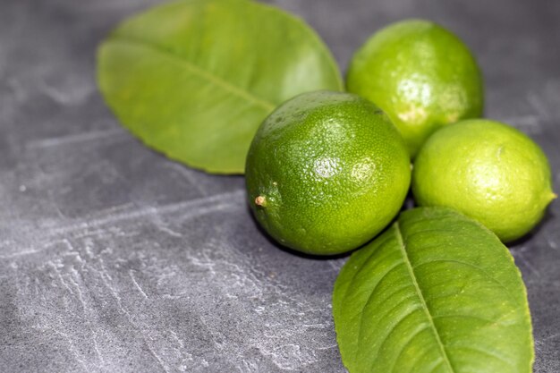 Conjunto de limones verdes fresco's sobre fondo gris