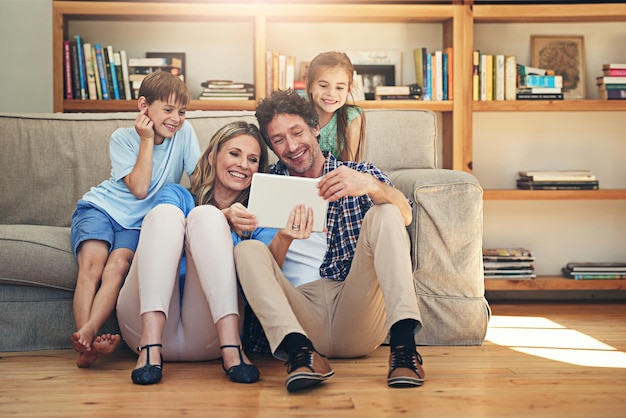 接続された家族は幸せな家族です自宅で一緒にデジタルタブレットを使用して幸せな家族のショット