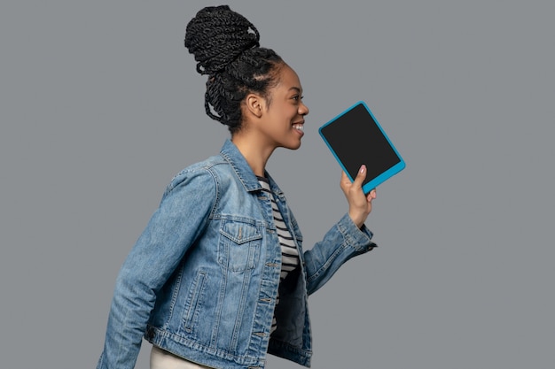 Connected. Picture of a dark-skinned young woman with a tablet in hands