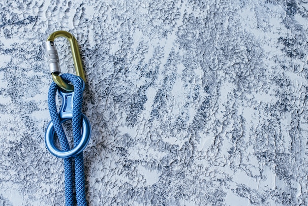 Connected pieces. Isolated  climbing equipment. Part of carabiner lying on the white and grey colored surface.