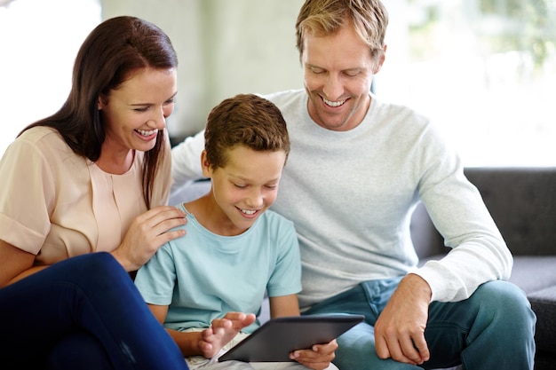 Фото Семейное общение снимок семьи, использующей цифровой планшет, сидя дома на диване