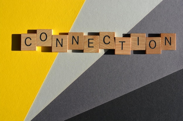 Connection word in wooden alphabet letters isolated on yellow and grey background