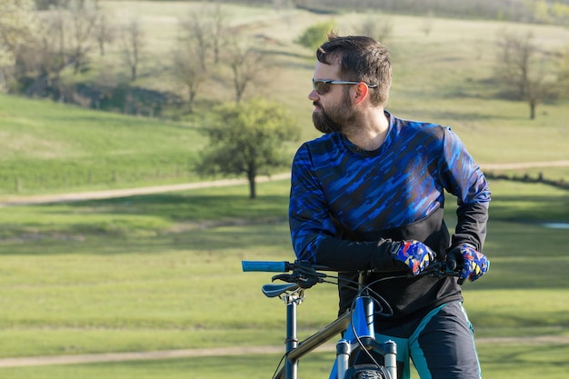 Conquering mountain peaks by cyclist in shorts and jersey on a modern carbon bike