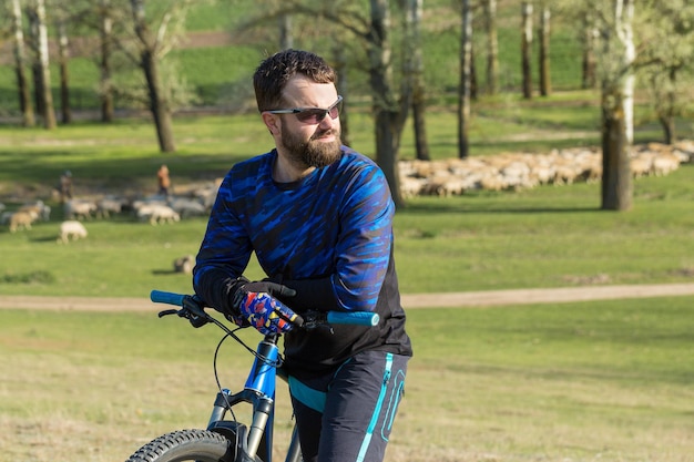 Conquering mountain peaks by cyclist in shorts and jersey on a modern carbon hardtail bike with an air suspension fork