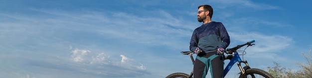 Conquering mountain peaks by cyclist in shorts and jersey on a modern carbon hardtail bike with an air suspension fork