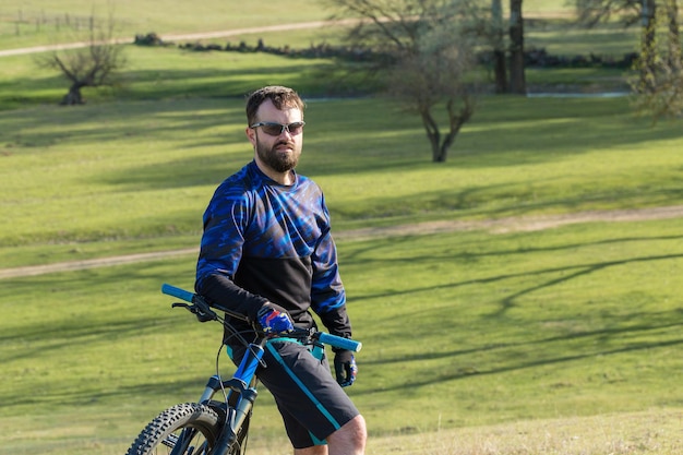 Conquering mountain peaks by cyclist in shorts and jersey on a modern carbon hardtail bike