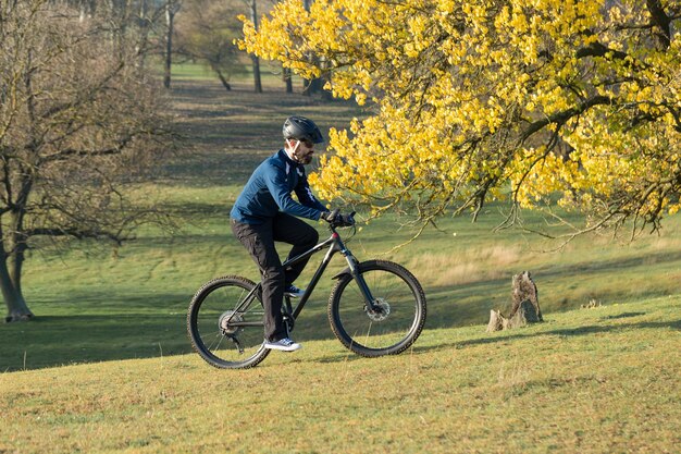 Conquering mountain peaks by cyclist in shorts and jersey on a modern carbon hardtail bike