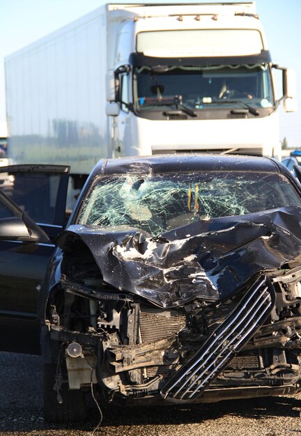 Foto conseguenze di una collisione ad alta velocità tra un'auto e un camion sull'autostrada