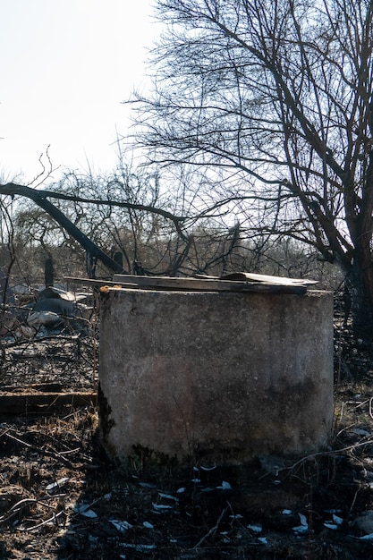 The consequences of a severe fire in a wooden house view of the burnt well and the burntout garden in the courtyard of the house careless handling of fire