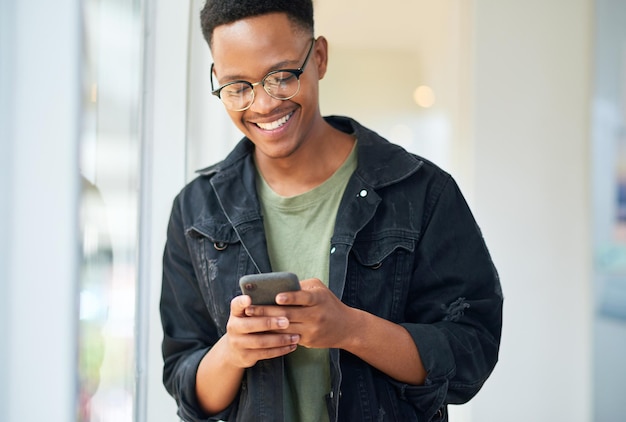 Consistente communicatie zorgt voor tevreden klanten Shot van een jonge zakenman die een smartphone gebruikt in een modern kantoor