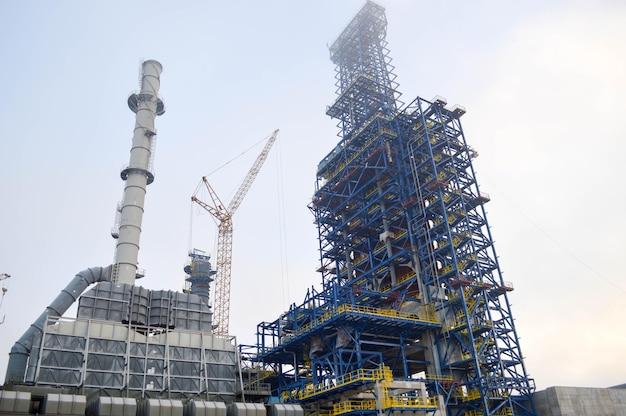 Constructie met kranen van een grote blauwe chemische fabriek in een petrochemische fabriek van een olieraffinaderij