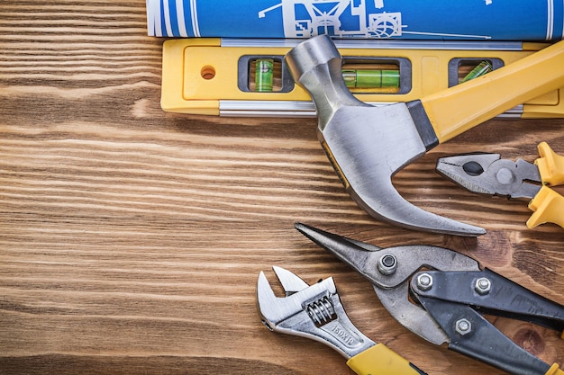 Constructieniveau tekening beschermende handschoenen klauwhamertang stalen snijder verstelbare sleutel op houten plank.