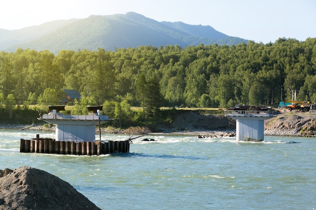 Construction of a bridge across a mountain river.