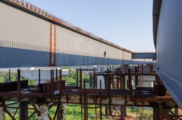 The construction of a bridge across the river with the supports, structural elements, cranes