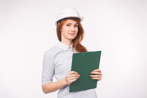 Construction, building and workers concept. beautiful woman engineer holding green clip board over