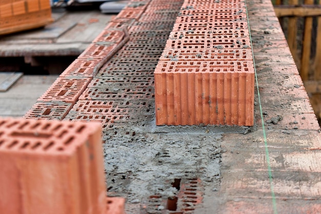 Construction of ceramic brick walls Keramoblock Hollow brick Construction of a red brick house Closeup Material for the construction of walls and partitions
