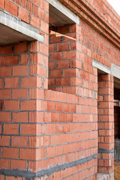 Photo construction of ceramic brick walls keramoblock hollow brick construction of a red brick house closeup material for the construction of walls and partitions