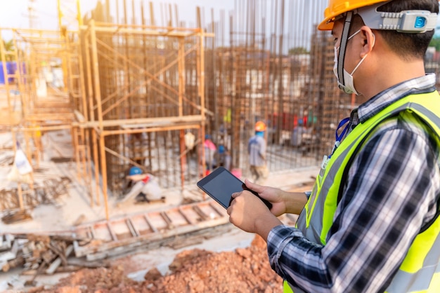 Construction civil engineer or architect with hardhat on construction site 