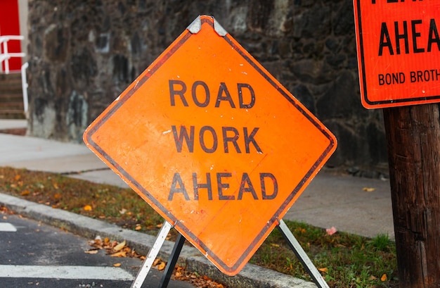 Photo construction cone standing alone on a sunlit urban street symbolizing safety roadwork caution a