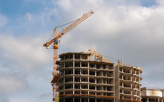 Photo construction a construction crane and a building under construction sky the clouds