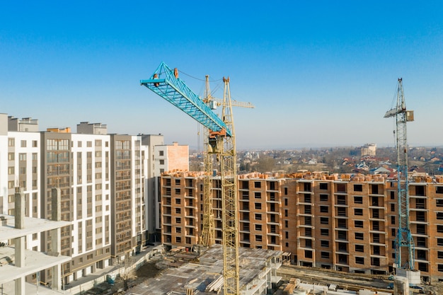 Costruzione e costruzione di grattacieli, industria delle costruzioni con attrezzature di lavoro e lavoratori. vista dall'alto, dall'alto. sfondo e trama