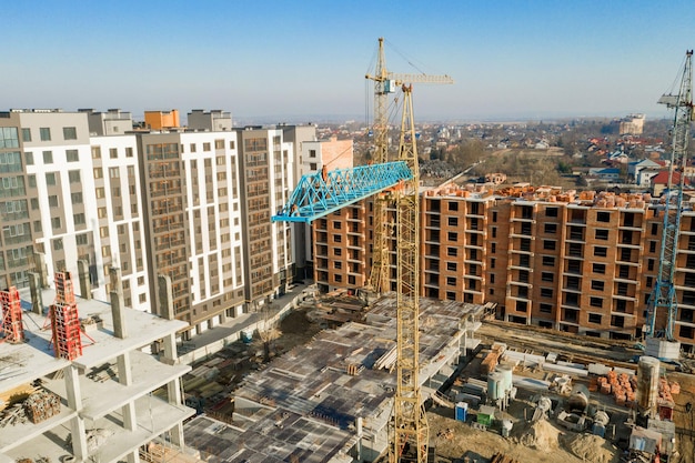 Construction and construction of highrise buildings the\
construction industry with working equipment and workers view from\
above from above background and texture