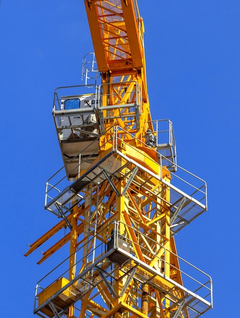 Construction crae tower with cabin close-up view on a blue sky background photo