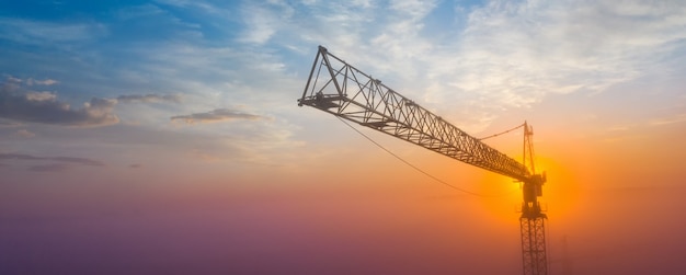 Photo construction crane on a background of the morning sky. panorama with space for text. concept, construction.