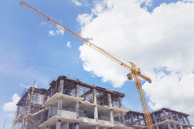 the construction crane and the building against the blue sky