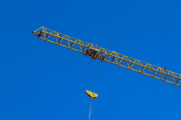 Construction crane and crane hook. Operating and lifting cargo concept, blue sky background photo