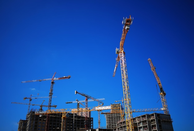 Construction cranes during building process city landscape