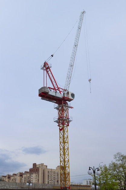 Construction cranes and buildings over sky