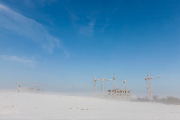 Construction cranes on a construction site in winter