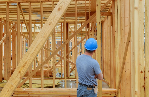 Photo a construction day laborer carrying wood beams