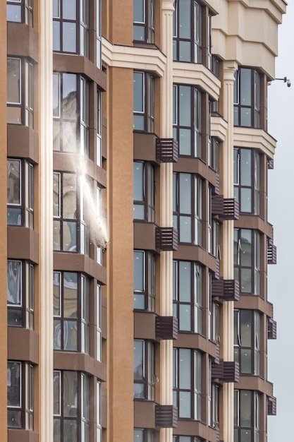 Construction debris flies from the window of a high-rise. real\
estate market. tall new building.