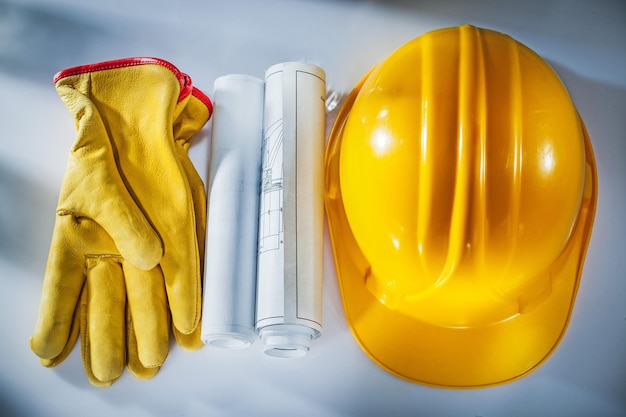 Construction drawings building helmet protective gloves on white background