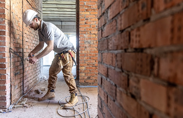 A construction electrician cuts a voltage cable during a repair.