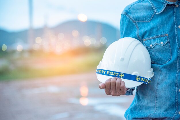 Construction engineer in Safety Suit Trust Team Holding White Yellow Safety hard hat Security Equipment on Construction Site.