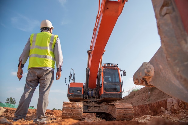 L'attrezzatura di protezione personale di usura dell'ingegnere di costruzione sta al sito della costruzione della strada