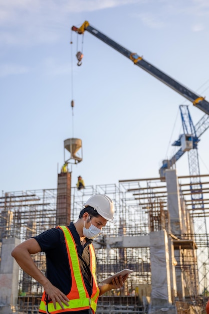 Construction engineers or managers and construction workers on\
a construction site project work plan for designing houses and\
industrial buildings