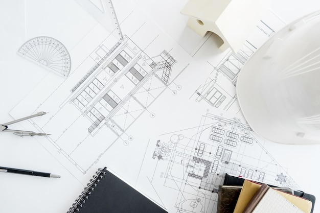 Foto attrezzatura da costruzione. lavoro di riparazione. disegni per la costruzione progetto architettonico, rotoli di design e bussola divisoria sul tavolo. concetto di strumenti di ingegneria con spazio di copia.