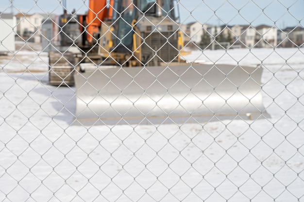 Construction equipment behind a wire mesh fence