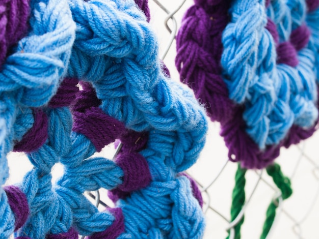 Construction fence covered with crocheted garden creatures like bugs and flowers by the Ladies Fancywork Society. Construction site of the Union Station in Denver, Colorado.